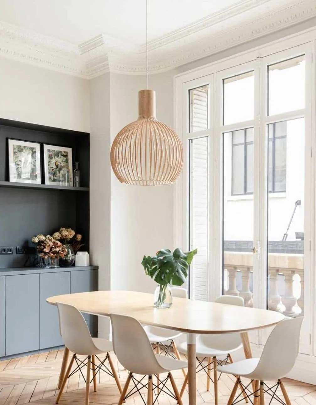 Comedor con suelo en espiga, molduras y lámpara de madera
